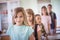 Large group of school children standing in classroom. Looking at camera.