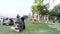 Large group of tourists people sitting on the lawn area and spending Holiday time in sunset time. Beluá¹› Maá¹­h Ramakrishna Swami