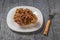 A large gyromitra mushroom on a white plate with a fork on a wooden table.