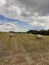 Large harvesting field of wheat and bales of hay