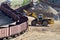 Large heavy front-end loader loading sand it to the freight train