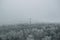 a large hill covered in snow and frost covering trees that is surrounded by gray fog