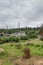 Large home surrounded by trees and forest and grass with overcast sky and large power lines