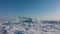 A large ice floe rises on a frozen lake.