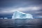 large iceberg floating in open sea under a precipitating sky