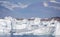 Large icebergs in front of the small community of Saqqaq with towering mountains behind in Disko Bay, Greenland