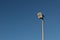 Large industrial exterior light isolated against a blue sky, copy space