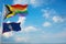 large Inter Progress Pride flag and flag of Guam state, USA waving at sky. Freedom and love, activism, community concept. Pride