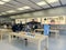 Large iPhone 15 wall poster and customer shopping for latest models on wooden table display at Apple Store in downtown, chain of