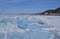 Large iridescent crystals blue white ice floes with cracks shine in the light the sun, the shore of lake Baikal, winter