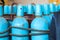 Large iron metal blue gas cylinders with oxygen, air, helium under excessive internal pressure to store compressed, liquefied and