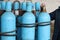 Large iron metal blue gas cylinders with oxygen, air, helium under excessive internal pressure to store compressed, liquefied and