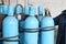 Large iron metal blue gas cylinders with oxygen, air, helium under excessive internal pressure to store compressed, liquefied and