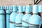 Large iron metal blue gas cylinders with oxygen, air, helium under excessive internal pressure to store compressed, liquefied and