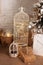 Large lanterns with lights glowing garlands and gifts stand on floor in room. Christmas living room is decorated with lanterns. Wo