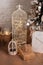 Large lanterns with lights glowing garlands and gifts stand on floor in room. Christmas living room is decorated with lanterns. Wo