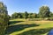 Large lawn in a holiday park for the family. Green and yellow lawn. Green trees in the park.