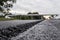 A large layer of fresh hot asphalt. Layer of asphalt raw material in a shallow depth of field. Rollers rollin fresh hot