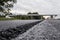 A large layer of fresh hot asphalt. Layer of asphalt raw material in a shallow depth of field. Rollers rollin fresh hot