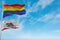 large lgbt flag and flag of California state, USA waving in the wind at cloudy sky. Freedom and love concept. Pride month.