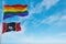 large lgbt flag and flag of Mississippi state, USA waving in the wind at cloudy sky. Freedom and love concept. Pride month.