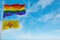 large lgbt flag and flag of New Mexico state, USA waving in the wind at cloudy sky. Freedom and love concept. Pride month.