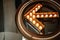 large luminous arrow decorated with light bulbs in the background of the airport interior