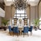 Large luxurious dining table in the large living room with high ceilings in a modern classic style with blue chairs and a white