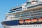 A large luxury cruise liner moored in the port of the Adriatic Sea, is waiting for passengers. There are four orange lifeboats