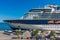 A large luxury cruise liner moored in the port of the Adriatic Sea, is waiting for passengers. There are four orange lifeboats