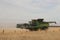 Large machinery harvesting a wheat crop on a farm in an agricultural, dry, windy and dusty farmland area near Melbourne,