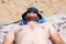 a large man in a Panama hat with white skin and a red beard is sunbathing on the beach on a sunny day. Rest and