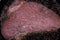A large marbled beef steak is fried in a mixture of olive and butter in a cast iron skillet