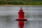 Large metal bright buoy on the river in the Rostov region. Designation of the depth and limit of movement for navigation of water