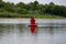 Large metal bright buoy on the river in the Rostov region. Designation of the depth and limit of movement for navigation of water