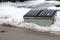 A large metal garbage bin sits on the side of a street in a condo corporation