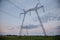 Large metal supports of power lines passing through agrarian fields. High voltage lines