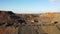 Large mining dump truck driving on a dusty road at the sunset aerial view.