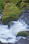 Large mossy rocks with rushing flowing water