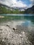 Large mountain lake blue water and rock bed on a sunny, cloudy summer day dramatic mountain cliffs in Austria, Tirol