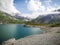 Large mountain lake blue water sunny, cloudy summer day with high contrast, dramatic mountain cliffs in Austria, Tirol