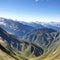 Large mountains with green glades into which clouds crash