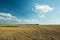 Large mowed field with bales of hay