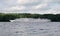 Large multi-deck passenger ship on the river. Wide river and dense forest in the background