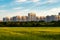 Large new residential area in an ecologically clean place of the city. A green field of wheat in the foreground, blurry