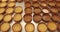 A large number of mini-tarts are laid out in even rows on a professional pastry table