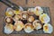 A large number of scallops are placed on the iron grate. which is placed on a hot coal stove in order to make the shellfish cooked