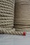 A large number of the twisted ropes in a roll. A thick rope on a counter of shop. Sale of various ropes