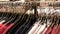 A large number of women`s clothing of different colors hangs on hangers and lies on the shelves in a clothing store of