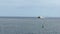 A large ocean ferry catamaran of yellow-white color moves on the water surface of the ocean.